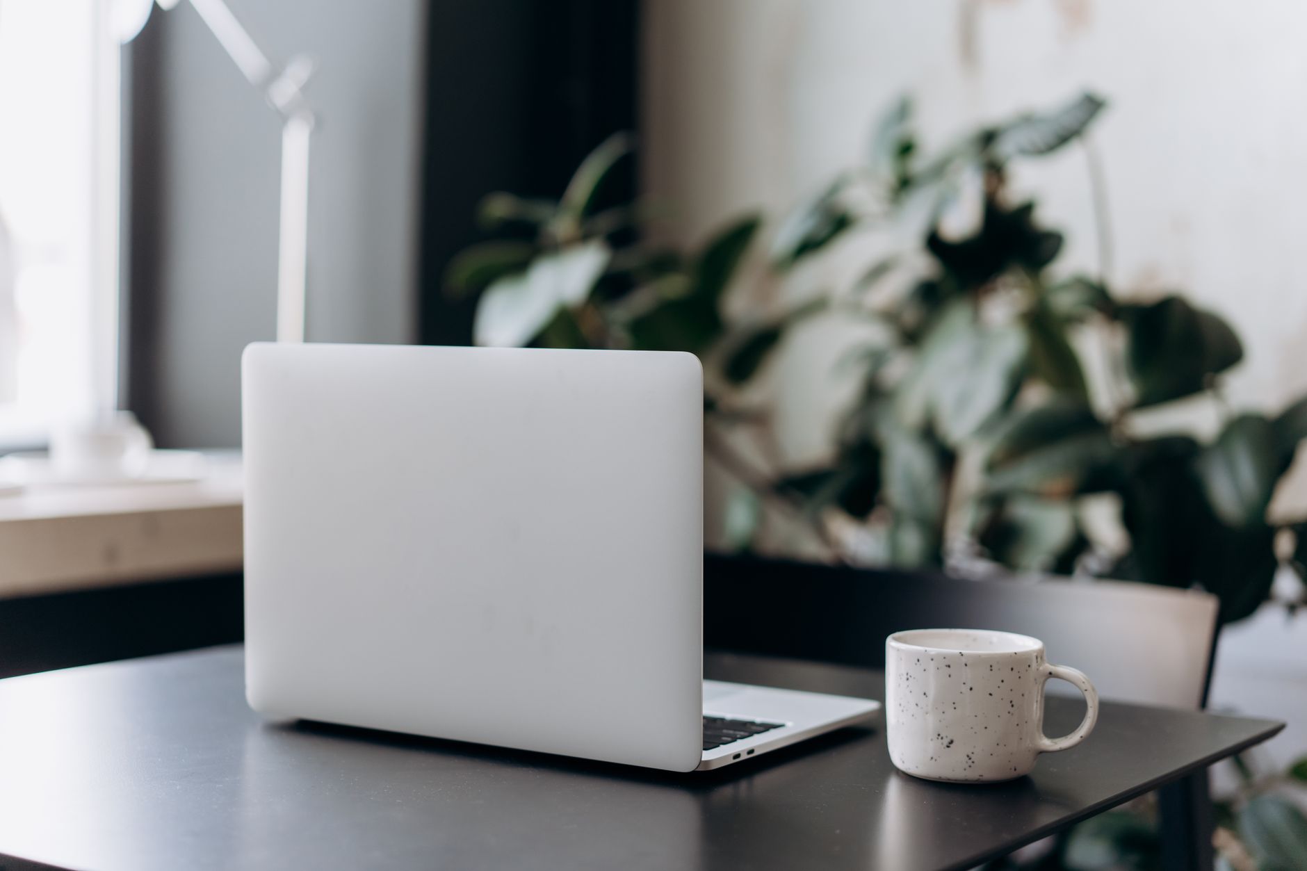 A desk by a window with a laptop